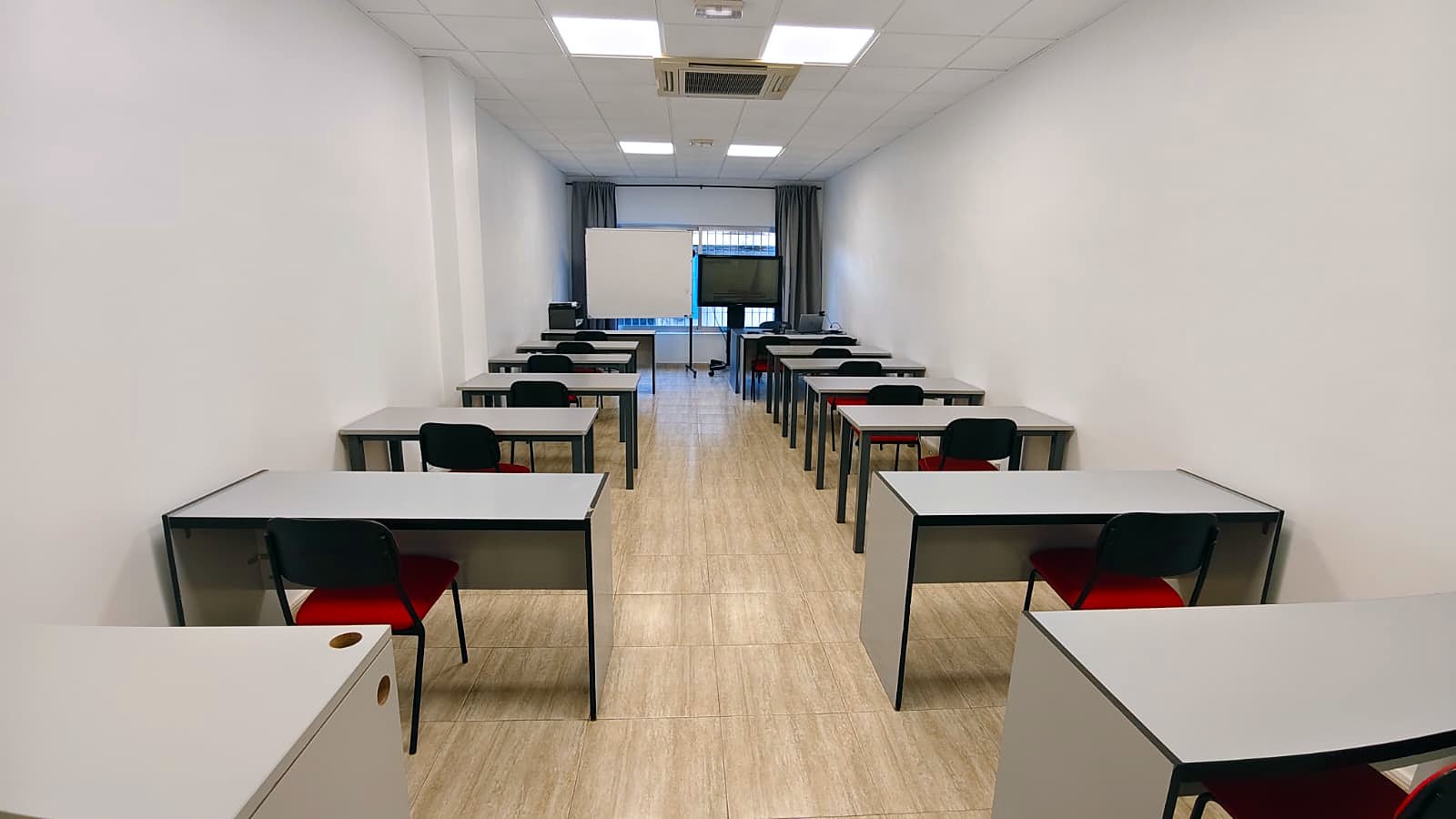 Aula de formación presencial con pantalla y pizarra en Galilea